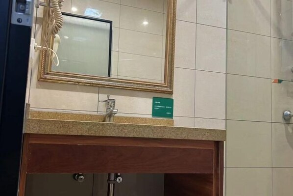 A bathroom with a mirror, a sink, and a towel rack.