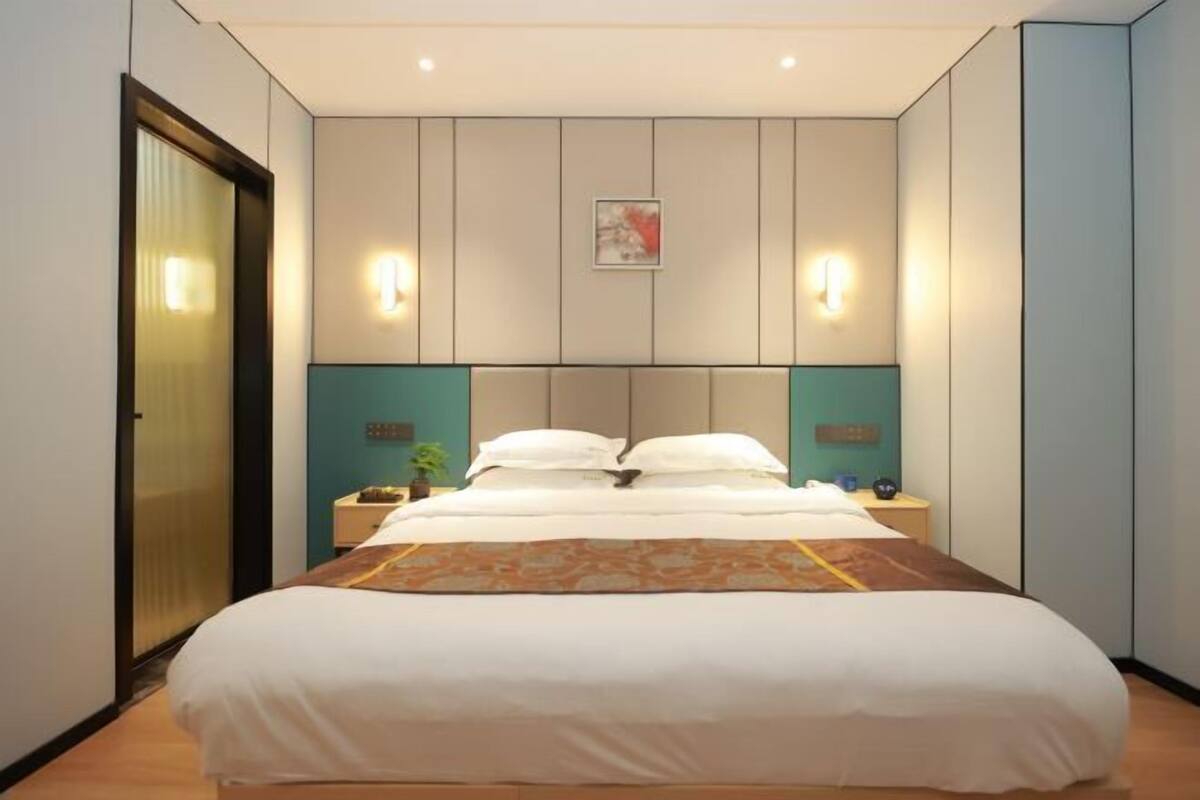 Une chambre d’hôtel équipée d’un lit, de tables de chevet et d’un système d’éclairage fixé au mur.