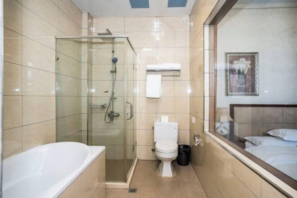 Une salle de bain moderne avec une douche à parois de verre, des toilettes blanches et une baignoire.