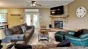 A living room with a sofa, a coffee table, and a fireplace. - Hillside Hideaway by Taylor Made Deep Creek (McHenry)