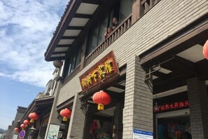 A building with a traditional architectural style, featuring a prominent sign with Chinese characters. - Yichun Yushuxia Hotel (Yichun)
