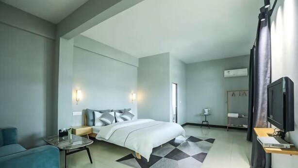 Una habitación de hotel moderna con una cama, un escritorio, una silla y un televisor.