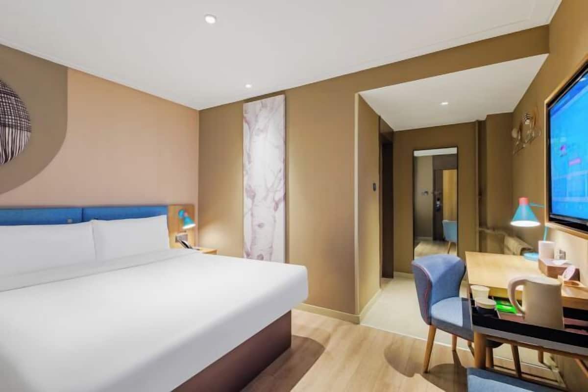 Une chambre d’hôtel équipée d’un lit, d’un bureau, d’une chaise et d’un téléviseur.