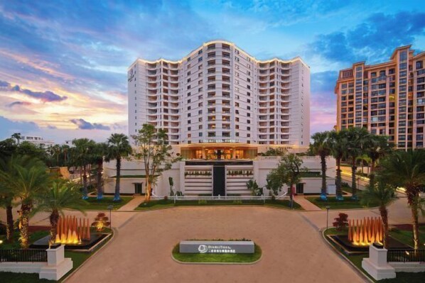 A multi-story hotel with a central entrance, surrounded by palm trees and a landscaped garden. - DoubleTree by Hilton Sanya Bay (Sanya)