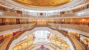 A multi-level atrium with a central open space, railings, and a decorative ceiling.
