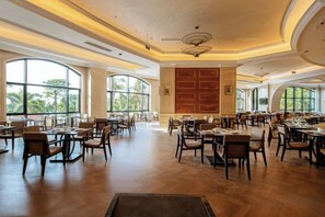 A spacious dining area with multiple tables and chairs, large windows, and a central decorative wall. - DoubleTree by Hilton Sanya Bay (Sanya)