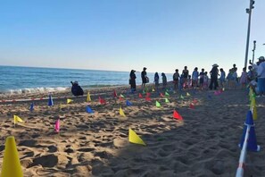 A beach with people and colorful flags on the sand. - DoubleTree by Hilton Sanya Bay (Sanya)