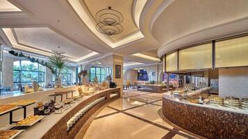 A spacious buffet area with a curved counter, large windows, and a modern ceiling design.