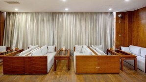Ein geräumiges Zimmer mit großem Fenster, Holzboden und einem Vorhang als Hintergrund.