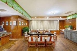 A conference room with a long table, chairs, a reception desk, and framed certificates on the wall. - Qihong International Hotel (Qimen)