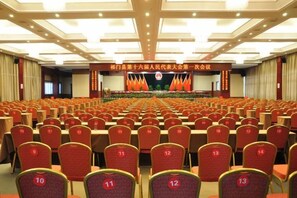 Una gran sala de conferències amb files de cadires i un escenari al capdamunt.