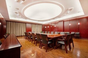 A conference room with a long table, chairs, and a wooden floor. - Qihong International Hotel (Qimen)