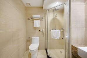 A bathroom with a toilet, a glass-enclosed shower, and a sink. - Qihong International Hotel (Qimen)