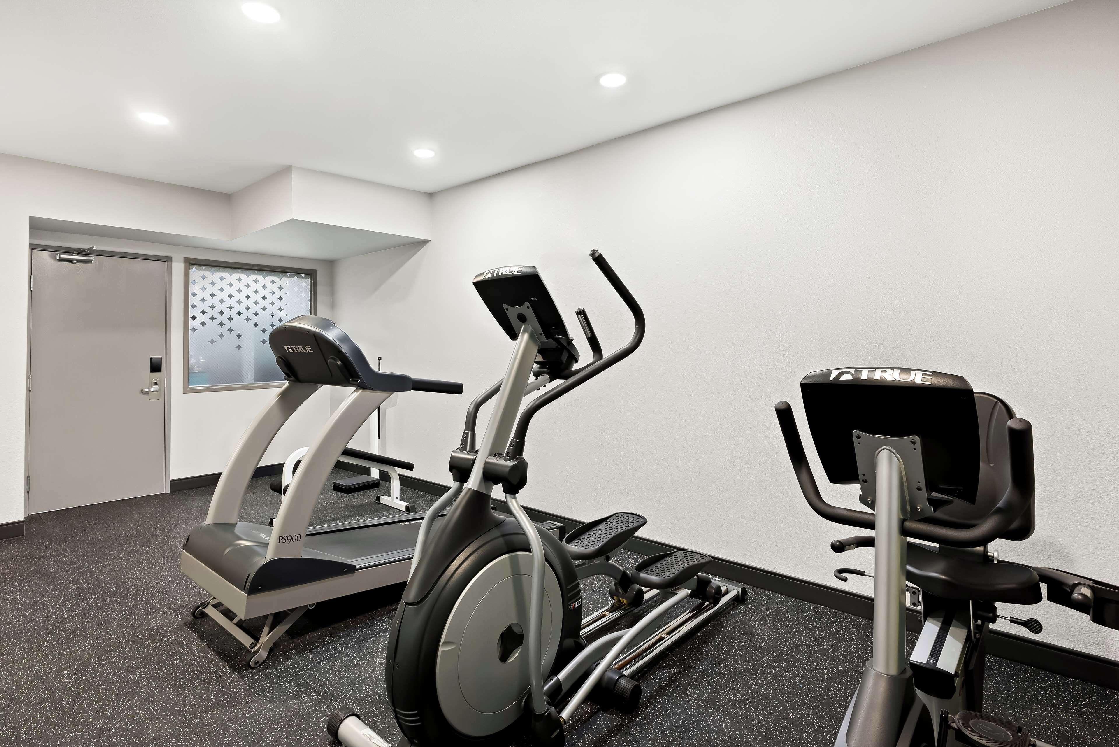 Un gimnasio con cintas de correr y elípticas.