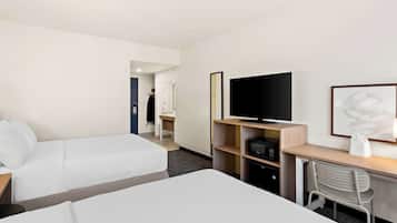 Une chambre d’hôtel comprenant un lit, un bureau avec une télévision, une chaise et une armoire.