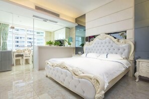 Een slaapkamer met een groot bed, een bureau en een stoel.