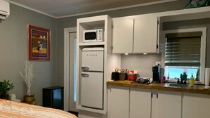 Une cuisine compacte équipée d’un four à micro-ondes, d’un réfrigérateur et d’un évier.