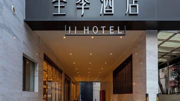 A hotel entrance with a sign reading 'JI HOTEL' in both Chinese and English.