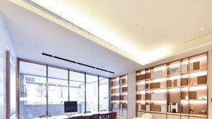 A modern library with large windows, multiple seating areas, and a well-lit interior. - Ji Hotel (Beijing)