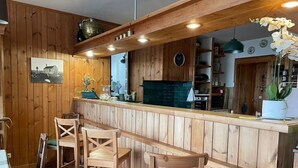 Ein Holzinterieur mit Barbereich, Barhocker und einer Wanduhr.