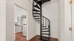 A modern interior with a spiral staircase leading to a second floor.