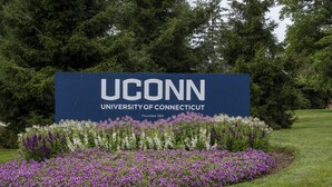 Señal de la Universidad de Connecticut (UCONN) con un jardín delantero.