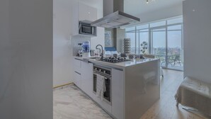 A modern kitchen with a central island, a microwave, and a coffee maker. - Icon Cibeles heart of La Roma (Mexico City)
