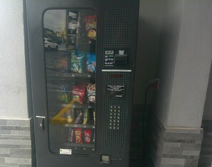 Una máquina expendedora con opciones de comida y una ranura para monedas.