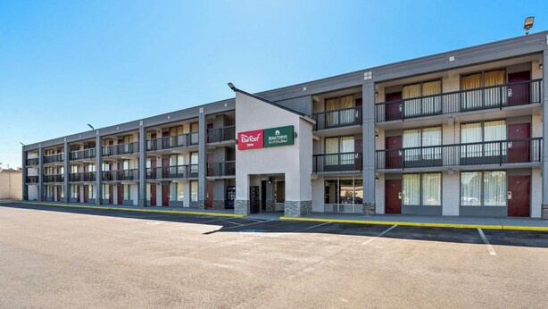 A multi-story motel with a sign for Red Roof Inn and HomeTown Suites. - HomeTowne Studios by Red Roof Richmond - Airport/Sandston (Sandston)
