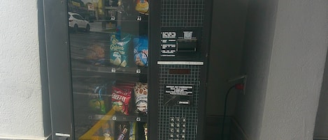 Un distributeur automatique de collations muni d’un lecteur de pièces.