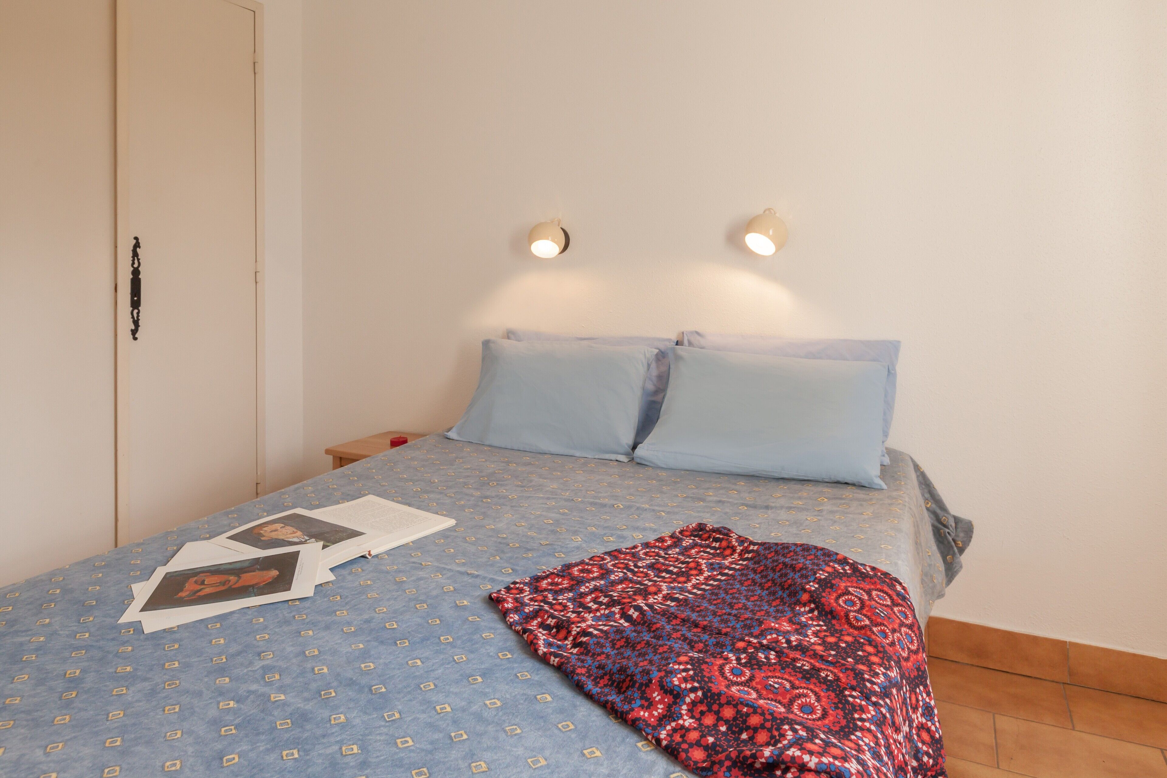Ein Schlafzimmer mit Bett, Kissen, Decke und Nachttisch.