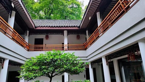 A traditional courtyard with a central tree, wooden railings, and white walls. - Wuyi Yangchun Shanju Guesthouse (Wuyi)