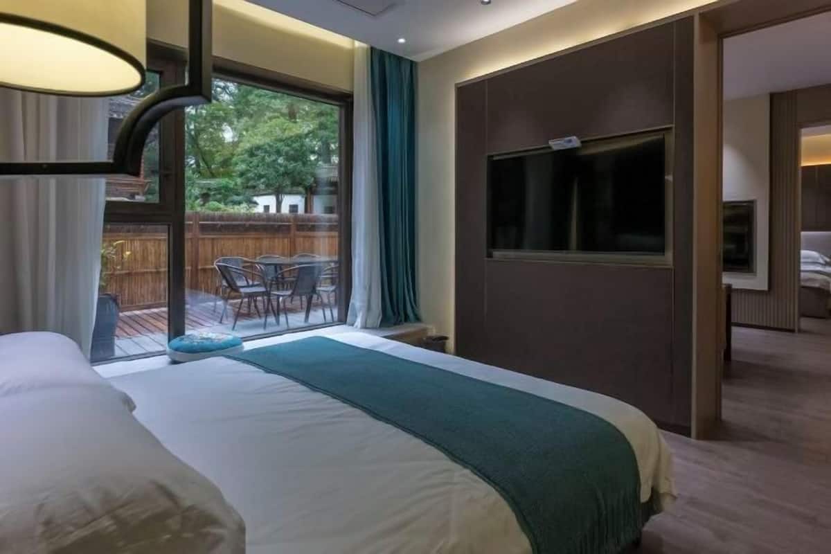 Une chambre d’hôtel avec un grand lit, une télévision et un balcon doté d’un espace salon extérieur.