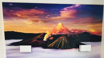 A wall with a large, detailed mural of a volcano erupting.