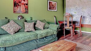 A green sofa with floral cushions, a wooden coffee table, and a map on the wall. - 2 bedroom accommodation in Wooler (Wooler)