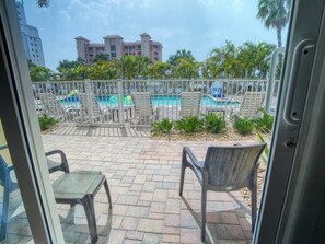 A pool area with lounge chairs and a view of a hotel building. - Queen Queen Gulf View Room (Treasure Island)