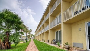 A hotel with a brick pathway leading to a building with multiple balconies. - King Room Marina View (Treasure Island)