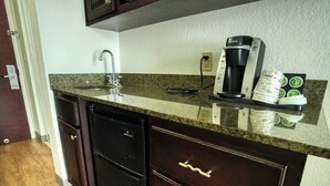 A kitchen with a granite countertop, a coffee maker, and a dishwasher. - King Room Marina View (Treasure Island)
