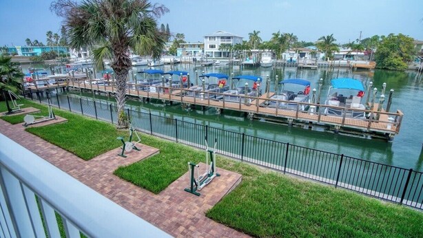 A marina with docked boats, a grassy area with exercise equipment, and a view of the water. - King Room Marina View (Treasure Island)
