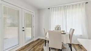 Ein Essbereich mit Tisch, Stühlen und einem fensterbepflanzten Fenster.