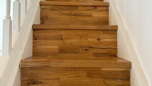 Un escalier en bois avec des rampes blanches.