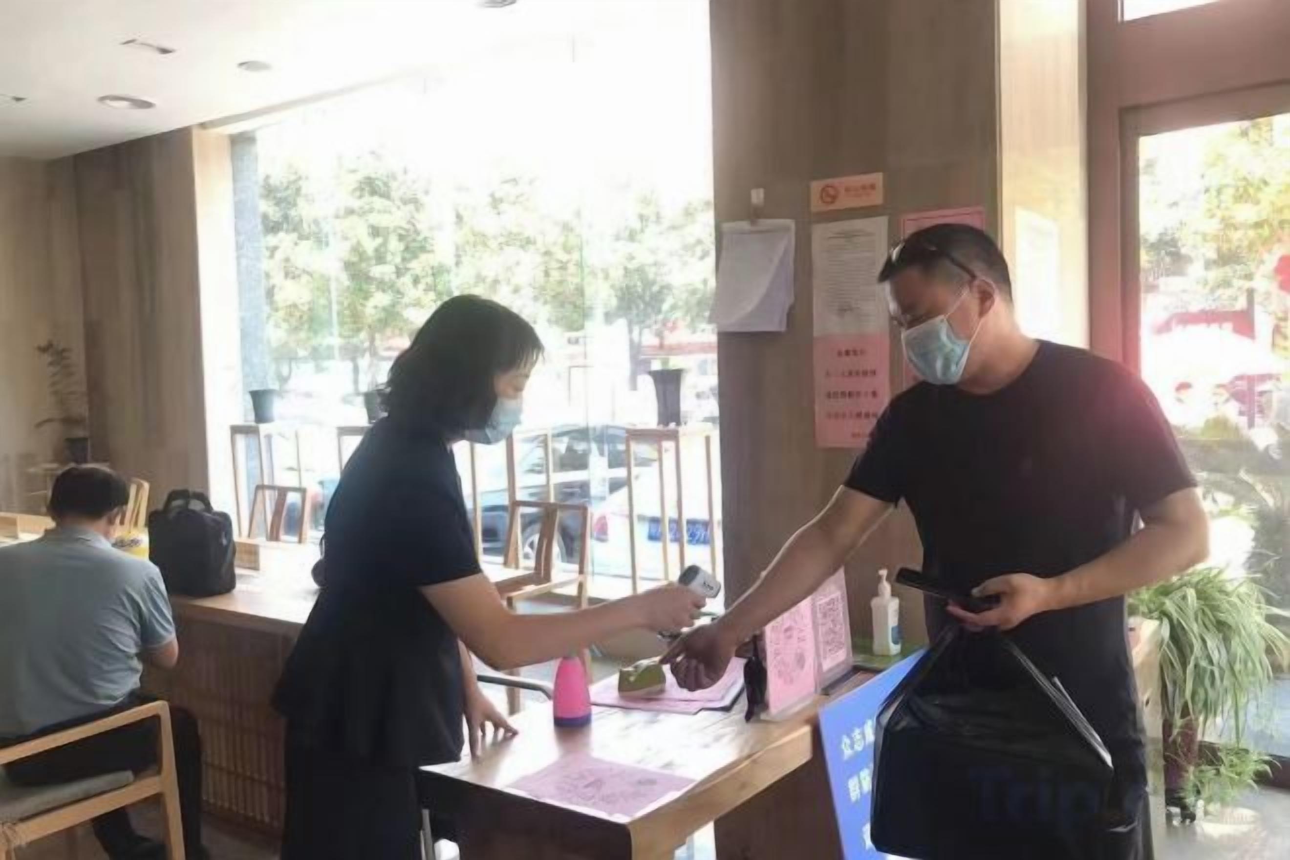 Ένα άτομο παραδίδει μια τσάντα σε ένα μέλος του προσωπικού σε ένα γκισέ με θέα προς το εξωτερικό.