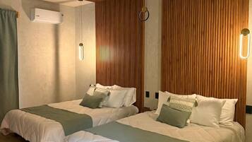 A hotel room with two beds, a ceiling fan, wooden paneling, a wall-mounted air conditioner, and a marble floor.