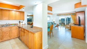 A modern kitchen with wooden cabinets and a dining area with a view of the city. - Fort Lauderdale Beach Resort 1 Bedroom Suite; RATES ARE NEGOTIABLE!!! (Fort Lauderdale)