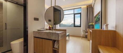 A modern bathroom with a shower, toilet, vanity, and a large mirror.