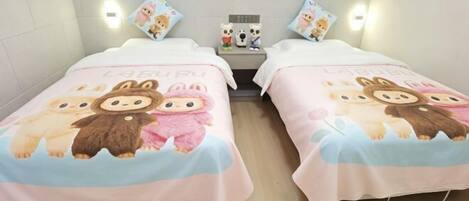 Two single beds with matching bedding, a nightstand with a lamp, and wall-mounted lights.