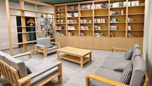 Una biblioteca moderna con estanterías de madera, asientos cómodos y un diseño minimalista.