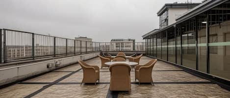 Une terrasse sur le toit, avec des sièges en plein air et une vue sur le paysage urbain.