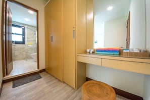 Un baño moderno con tocador de madera, espejo y perchero.
