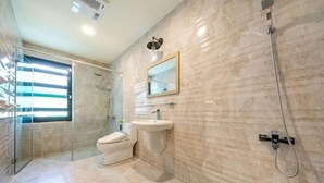 A modern bathroom with a glass shower enclosure, a toilet, and a sink. - Taitung Yipin Garden Bed and Breakfast (Taitung)